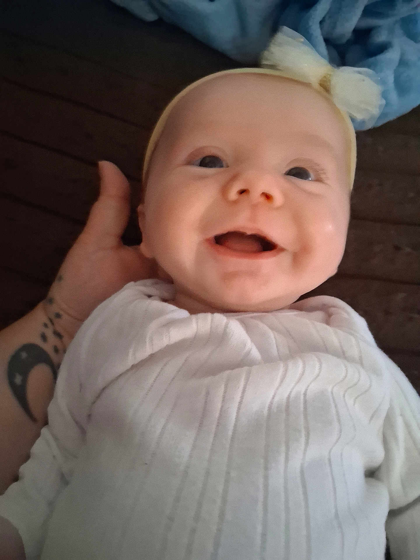 Lennon joined the competition — help win amazing prizes! baby, smiling, infant, white_blanket, headband, yellow_bow, tattoo, hand, close_up, face, happy, cute, child, portrait, indoor, soft_light, skin, clothing, person, newborn