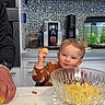 Liam a rejoint le concours — aidez-le/la à gagner de superbes lots ! adult_hand, appliance, cabinet, child, coffee_machine, cookie, countertop, cutting_board, fish_tank, food_preparation, fruit, glass_bowl, happy, indoor, kitchen, mosaic_tile, person, playful, smile, toddler