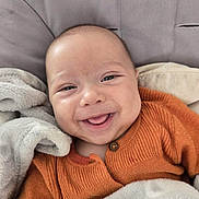 Saphir participe au concours pour gagner de l'argent avec cette photo : baby, smile, face, child, cozy, blanket, orange_sweater, happy, cute, infant, portrait, closeup, soft, comfort, warm, snuggle, head, eyes, skin, expression