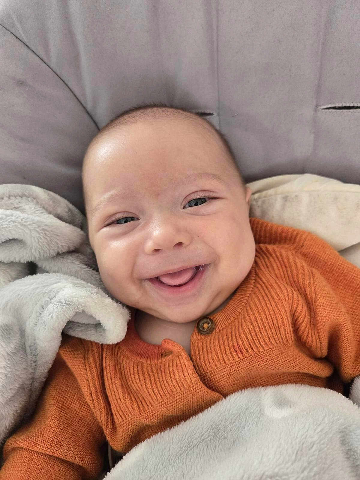 Saphir participe au concours pour gagner de l'argent avec cette photo : baby, smile, face, child, cozy, blanket, orange_sweater, happy, cute, infant, portrait, closeup, soft, comfort, warm, snuggle, head, eyes, skin, expression