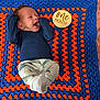 Scot joined the competition — help win amazing prizes! baby, newborn, infant, crochet_blanket, blanket, blue, orange, one_month_sign, milestone_prop, wooden_sign, smiling, happy, lying_down, onesie, socks, portrait, face, head, hands, cozy