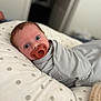 baby, infant, newborn, pacifier, swaddle, pillow, polka_dot, blue_eyes, blanket, nursery, portrait, close_up, soft_focus, indoor, resting, cute, curious, skin, sleepwear, bedding