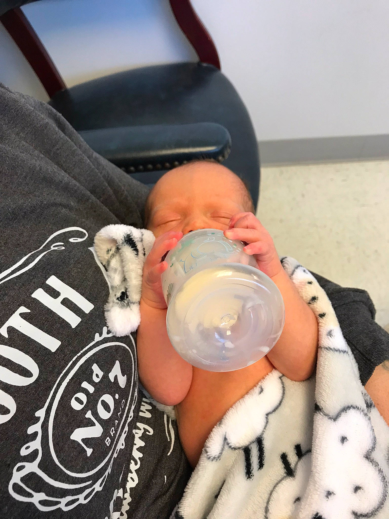 Alexander is registered to the contest to win money with this photo: baby, baby_bottle, baby_toddler_clothing, bottle, comfort, drink, drinkware, elbow, hat, human_body, human_leg, knee, nail, pattern, person, plastic_bottle, sleeve, t_shirt, thigh, toddler