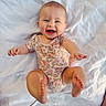 baby, infant, smiling, happy, onesie, floral_pattern, barefoot, reaching, white_blanket, lying_down, cute, child, portrait, skin, cheerful, small_hands, small_feet, indoor, light, playful