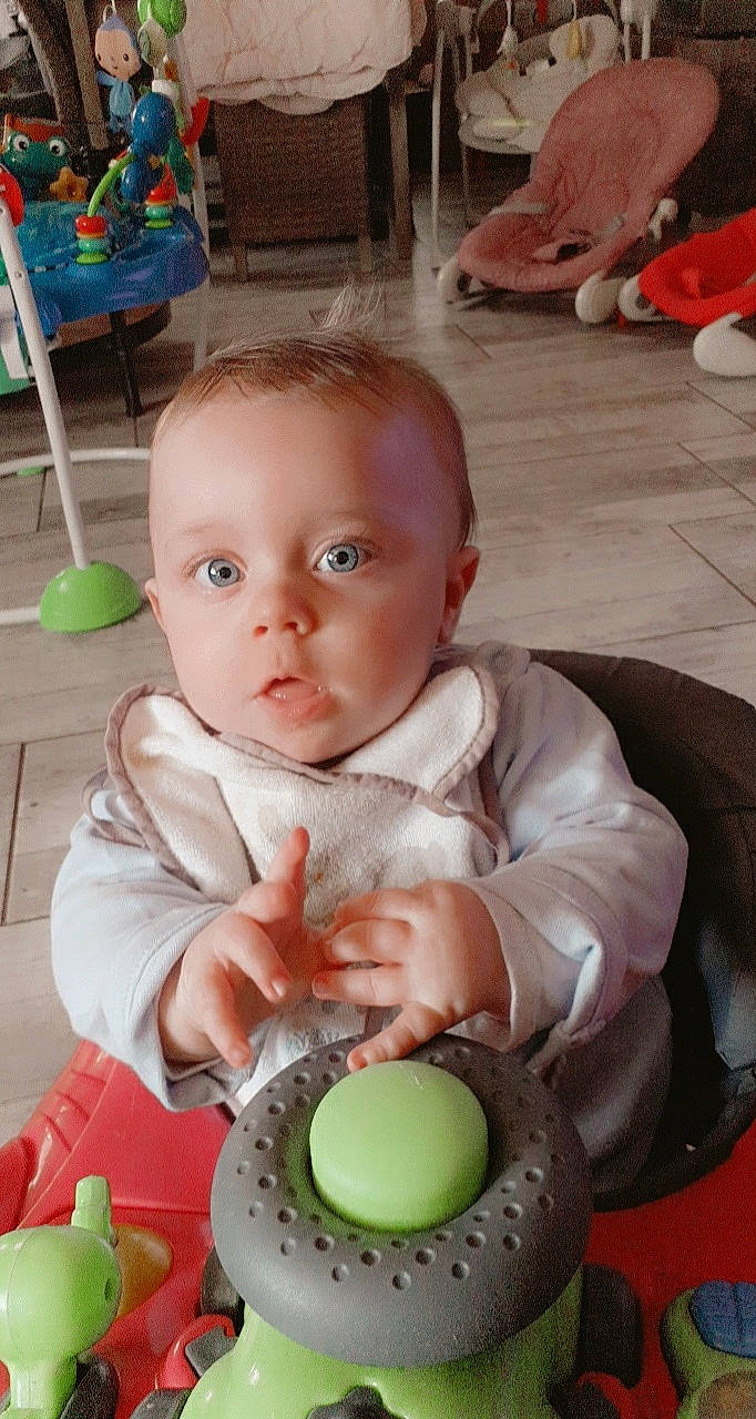 Louka a rejoint le concours — aidez-le/la à gagner de superbes lots ! baby, baby_playing_with_toys, baby_products, baby_toddler_clothing, baby_toys, chair, cheek, child, facial_expression, fun, green, happy, iris, nose, person, play, product, sitting, skin, toddler