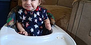 Atticus is registered to the contest to win money with this photo: toddler, baby_walker, smile, child, indoor, furniture, couch, wood_paneling, clothing, happy, person, hair, face, footwear, plastic, seat, home, carpet, toy, room
