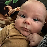 Edwin is registered to the contest to win money with this photo: baby, infant, face, hand, eyes, cheeks, skin, clothing, blanket, portrait, closeup, cute, young_child, indoor, cozy, expression, curious, resting, person, head