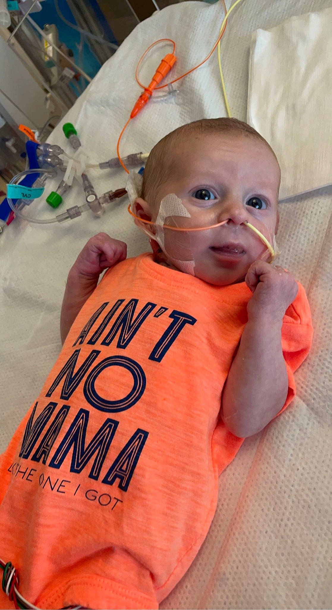 Luke is registered to the contest to win money with this photo: baby, baby_products, baby_toddler_clothing, cheek, child, eyelash, eyewear, finger, font, medical_equipment, orange, person, personal_protective_equipment, product, room, service, sleeve, stethoscope, t_shirt, textile