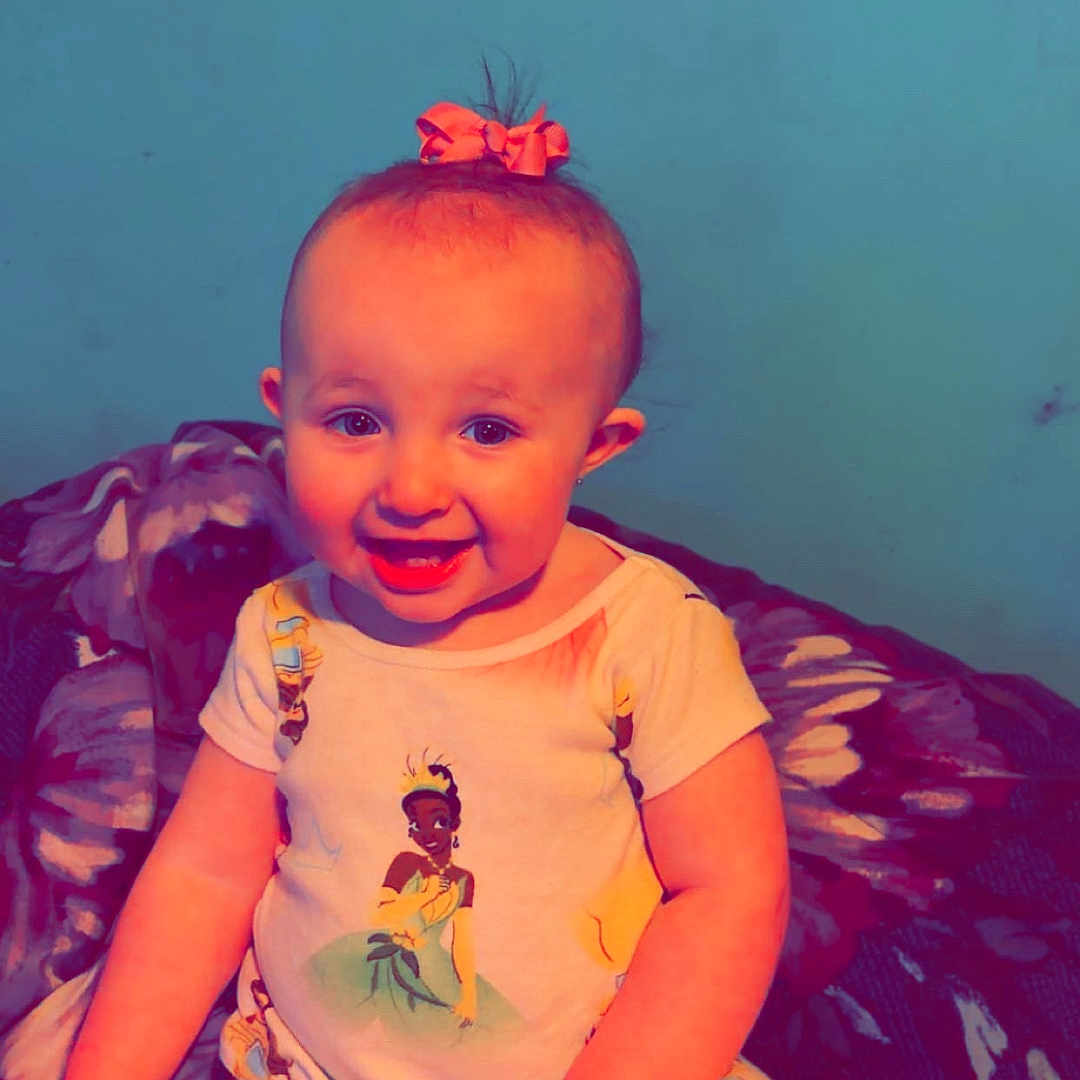 Ruby joined the competition — help win amazing prizes! baby, child, smiling, pajamas, bow, indoor, portrait, sitting, blanket, cute, happy, person, clothing, face, headwear, patterned, wall, young_child, infant, colorful
