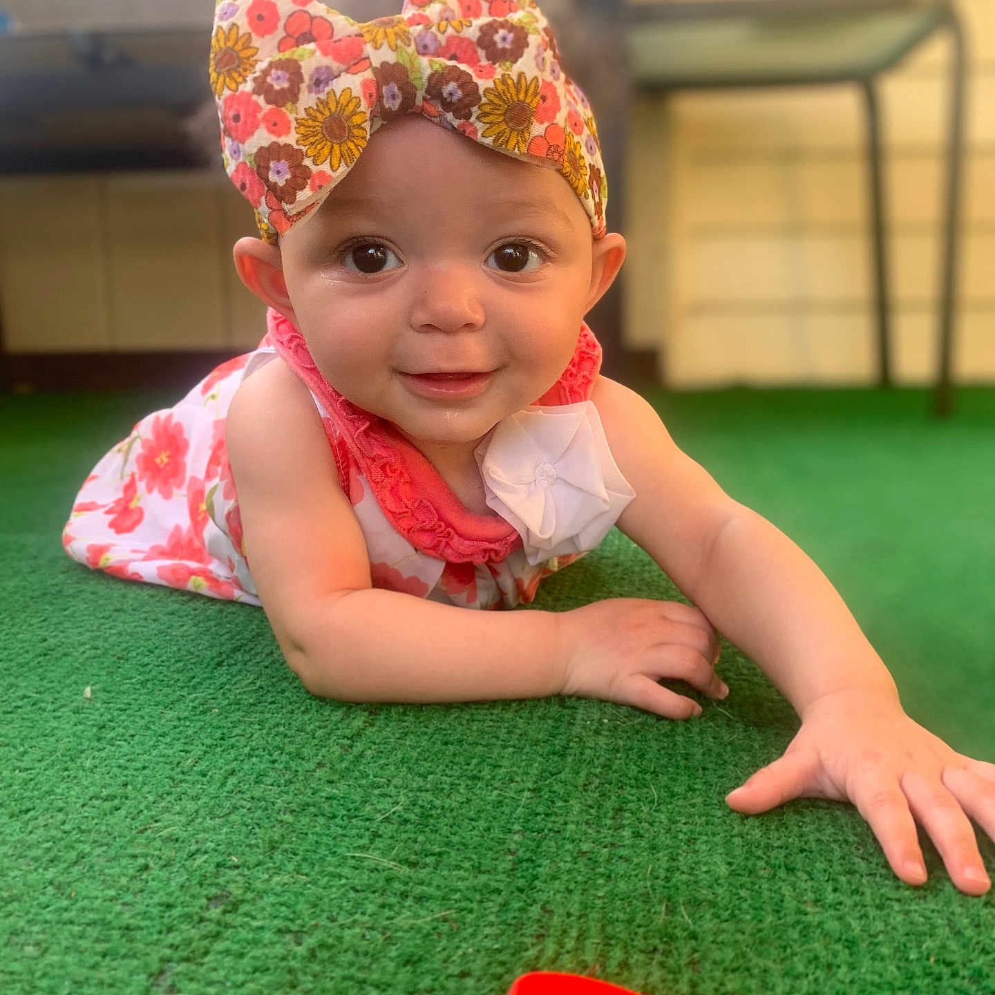 Scotlynn is registered to the contest to win money with this photo: baby, carpet, child, colorful, cute, dress, face, floral, green, hand, happy, headband, indoors, infant, person, play, portrait, smiling, toy, young