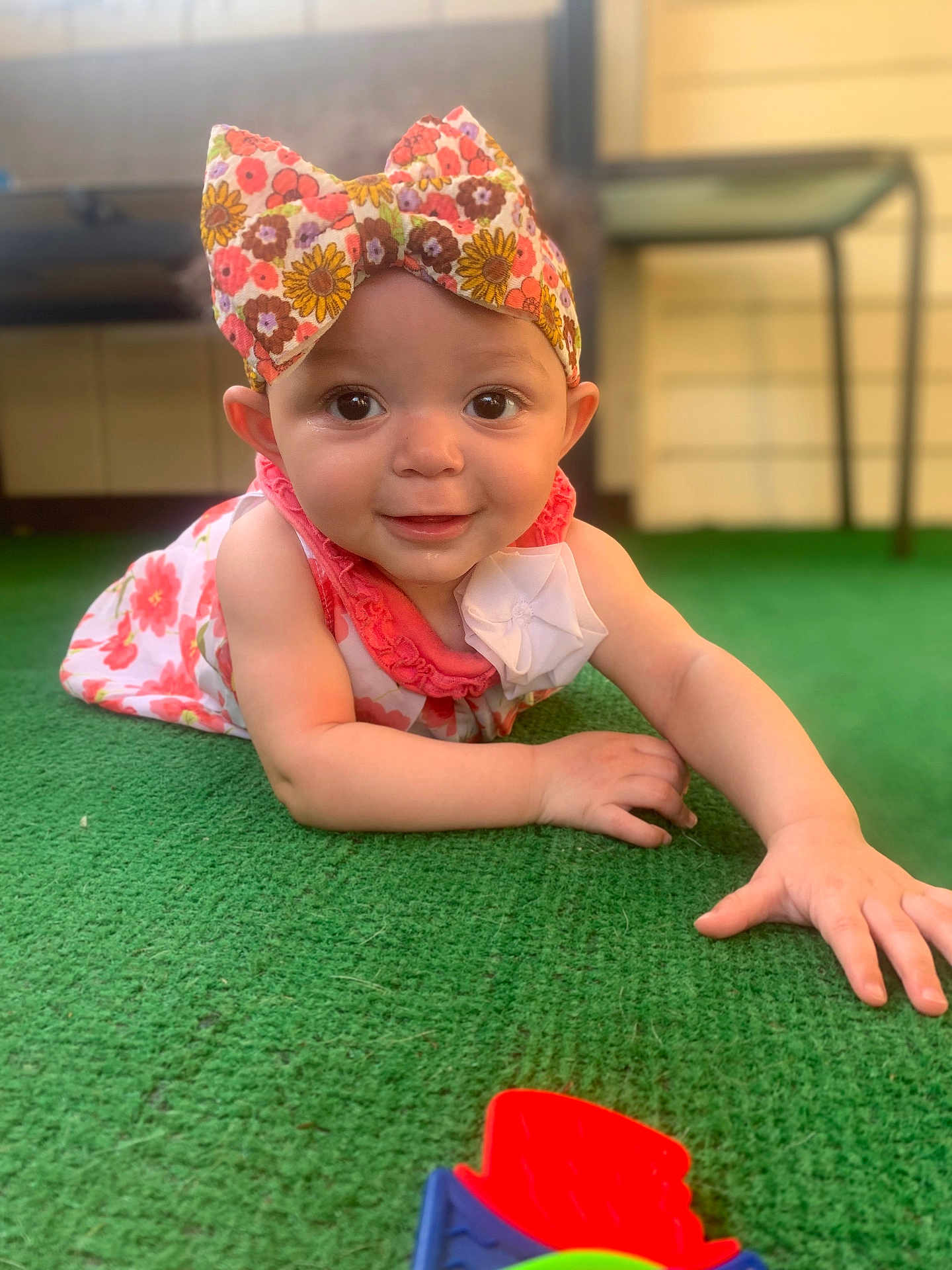 Scotlynn is registered to the contest to win money with this photo: baby, child, headband, floral, dress, toy, carpet, green, smiling, cute, indoors, person, face, hand, play, infant, happy, colorful, portrait, young