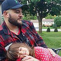 Faythe joined the competition — help win amazing prizes! baby, baseball_cap, beard, cap, event, eyewear, facial_hair, fun, grass, happy, hat, headwear, moustache, pattern, person, plaid, plant, recreation, sitting, tartan