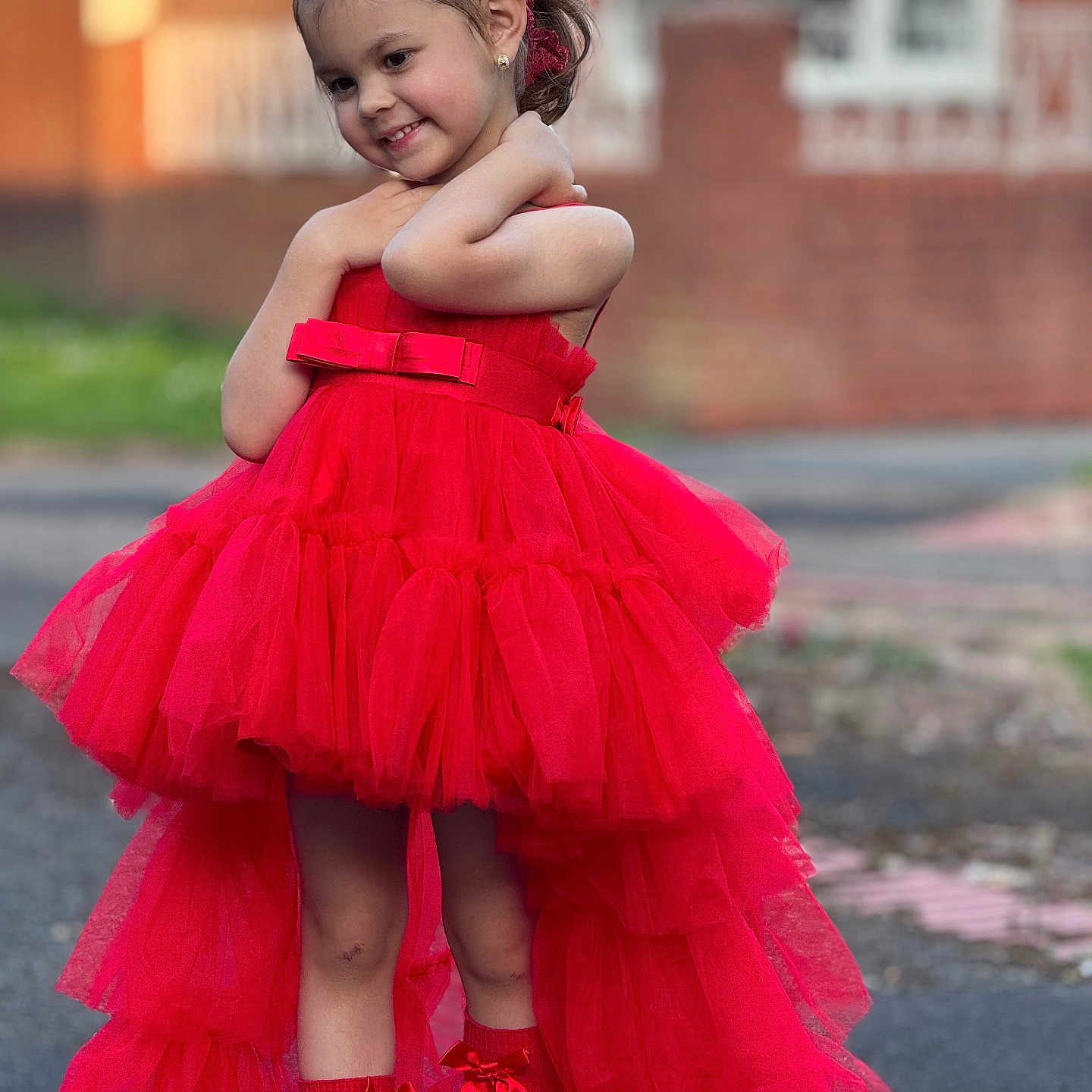 Melissa Maria is registered to the contest to win money with this photo: child, girl, red_dress, dress, tulle, ribbons, headband, smile, posing, outdoor, street, brick_wall, fashion, portrait, happy, cute, feet, socks, earrings, young