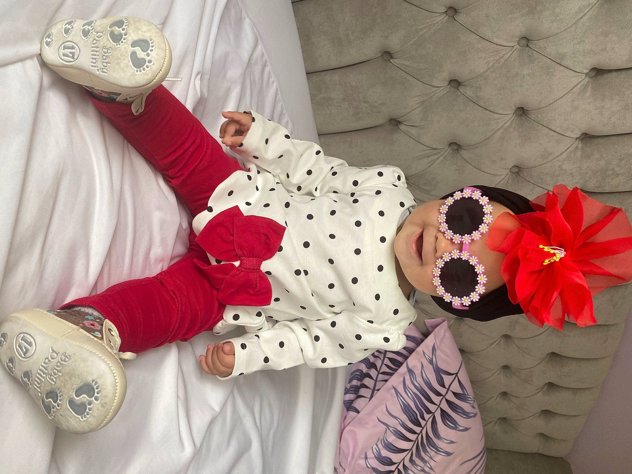 Melissa Maria is registered to the contest to win money with this photo: arm, baby_toddler_clothing, child, flower, flowerpot, hand, happy, headwear, linens, pattern, person, petal, pink, plant, product, shoe, sleeve, sunglasses, textile, thigh