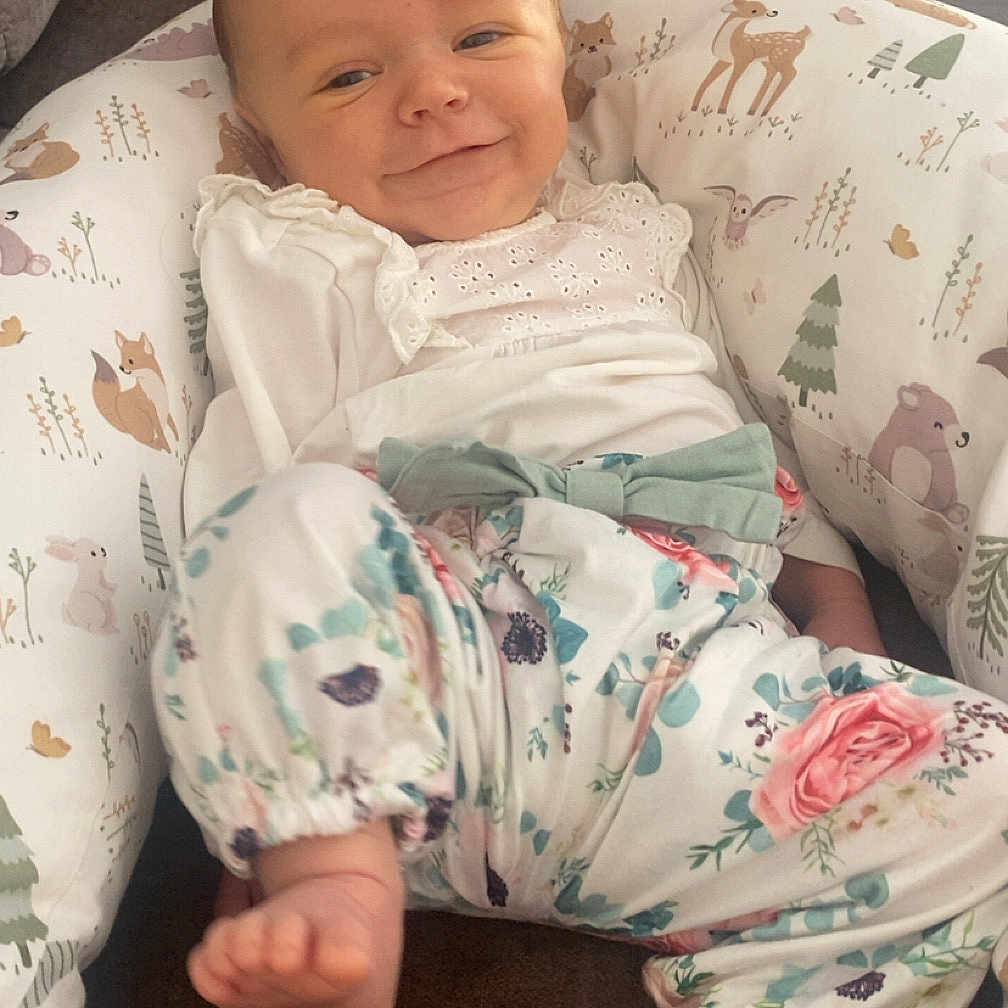 Léanor participe au concours pour gagner de l'argent avec cette photo : baby, bear, blanket, child, couch, cushion, cute, deer, face, floral_pants, foot, fox, green_bow, indoors, infant, rabbit, relaxed, smiling, white_top, woodland_pattern