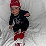 Elias joined the competition — help win amazing prizes! baby, infant, smiling, christmas, holiday, red_hat, red_booties, black_outfit, white_blanket, pom_pom, festive, cozy, cute, portrait, sitting, indoors, celebration, child, happy, soft_texture