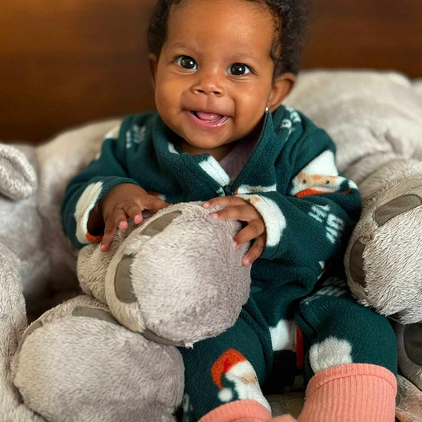 Amélia participe au concours pour gagner de l'argent avec cette photo : baby, blanket, child, childhood, comfort, cozy, cute, fuzzy, happy, indoors, infant, pajamas, person, plush_toy, portrait, sitting, smiling, soft_toy, teddy_bear, warm