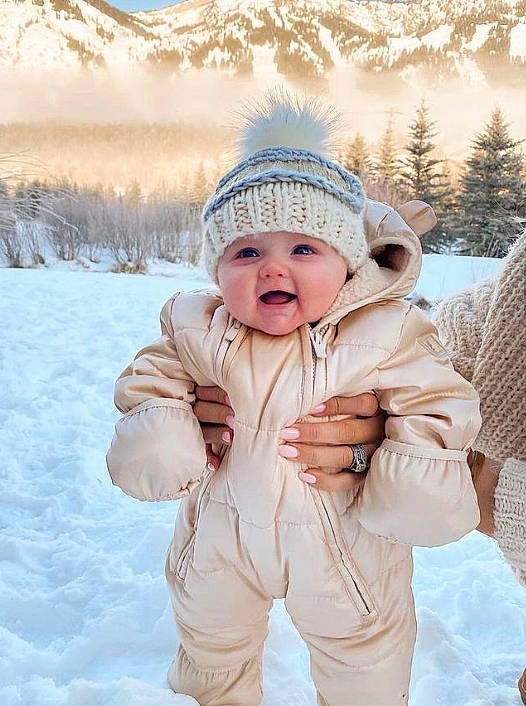 Cole Ryder is registered to the contest to win money with this photo: baby, baby_toddler_clothing, cap, child, face, freezing, gesture, happy, headwear, mountain, people_in_nature, person, plant, skin, sky, sleeve, smile, snow, toddler, tree