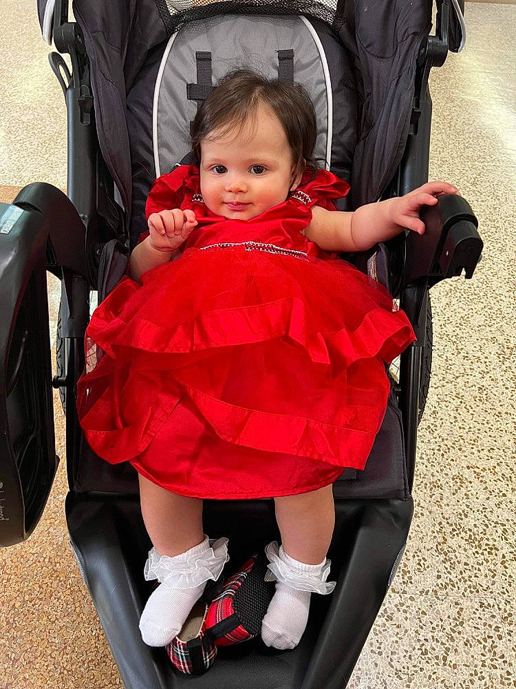Freya is registered to the contest to win money with this photo: baby, baby_carriage, baby_products, baby_toddler_clothing, bag, chair, child, comfort, dress, event, eye, face, fashion_accessory, fun, happy, magenta, person, sitting, tire, toddler