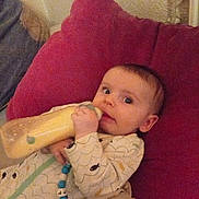 Naël a rejoint le concours — aidez-le/la à gagner de superbes lots ! baby, bottle, pillow, onesie, pacifier_clip, indoor, child, infant, feeding, sleepwear, blanket, face, hand, toy, person, cute, lying_down, cozy, bedroom, relaxed