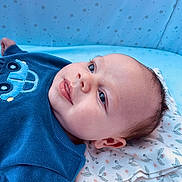 Jarrah joined the competition — help win amazing prizes! baby, infant, blue_sweater, car_design, blanket, floral_pattern, star_pattern, lying_down, portrait, cute, soft_texture, indoors, child, face, head, skin, expression, eyes, ear, cozy