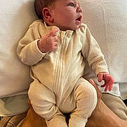 Jarrah is registered to the contest to win money with this photo: newborn, baby, infant, onesie, clothing, hands, face, adult_hands, blanket, soft_texture, indoor, portrait, cute, curious, cozy, human, skin, sleepwear, newborn_clothing, baby_onesie