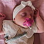 baby, sleeping, pacifier, headband, blanket, pink, cream, clothing, infant, cute, peaceful, soft_texture, floral, embroidery, hand, face, portrait, indoors, child, toddler
