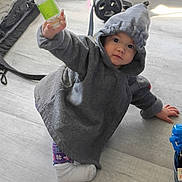 Manzanita joined the competition — help win amazing prizes! toddler, child, hooded_jacket, bottle, sitting, floor, indoor, toy, stroller, casual, cozy, clothing, person, baby, cute, hand, footwear, playful, expression, young_child