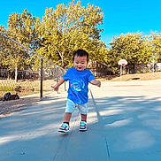 Edvenson joined the competition — help win amazing prizes! toddler, child, outdoor, basketball_court, blue_shirt, shorts, sneakers, sunny_day, trees, fence, smiling, walking, person, playing, daylight, young_child, recreation, happy, sport, casual_clothing