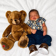 Kaos is registered to the contest to win money with this photo: baby, teddy_bear, plaid_shirt, navy_pants, brown_shoes, sleeping, soft_blanket, cute, infant, toy, cozy, child, lying_down, indoors, portrait, adorable, peaceful, plush, baby_fashion, resting