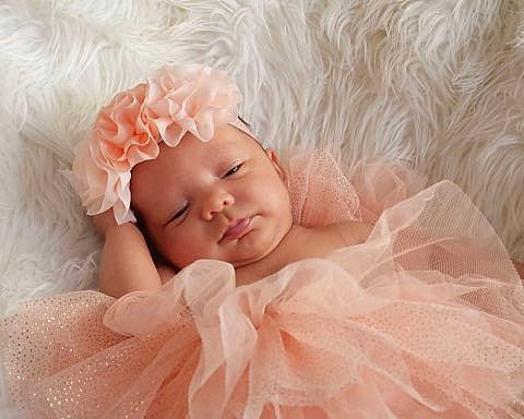 Sutton is registered to the contest to win money with this photo: baby, baby_sleeping, baby_toddler_clothing, bridal_accessory, child, comfort, embellishment, facial_expression, finger, happy, hat, headgear, headpiece, headwear, iris, linens, peach, person, petal, pink