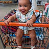 Ocean is registered to the contest to win money with this photo: baby, child, shopping_cart, smiling, headband, sandals, indoor, store, retail, person, happy, cute, clothing, seat, bag, footwear, holding, bright, portrait, infant