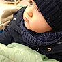 toddler, child, face, winter_hat, scarf, jacket, blanket, indoor, shopping, curious, closeup, profile, warm_clothing, eyelashes, soft_light, baby, cute, cozy, portrait, expression