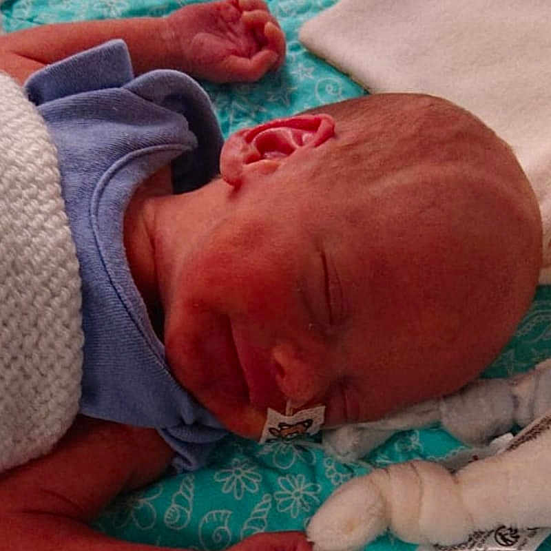 Lincoln joined the competition — help win amazing prizes! architecture, baby, bed, blanket, bodypart, building, clothing, face, finger, furniture, glove, hand, head, hospital, newborn, person, photography, portrait, quilt, sleeping