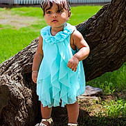 Valerie is registered to the contest to win money with this photo: toddler, child, dress, blue_dress, sandals, tree, grass, outdoor, sunlight, bracelet, young_child, nature, portrait, curly_hair, greenery, garden, standing, footwear, cute, daylight