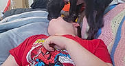 Rosey is registered to the contest to win money with this photo: animal, black_dog, blanket, child, couch, cozy, dog, door, fun, glass_pane, home, indoor, interaction, lying_down, person, pet, playing, spiderman, stickers, tshirt