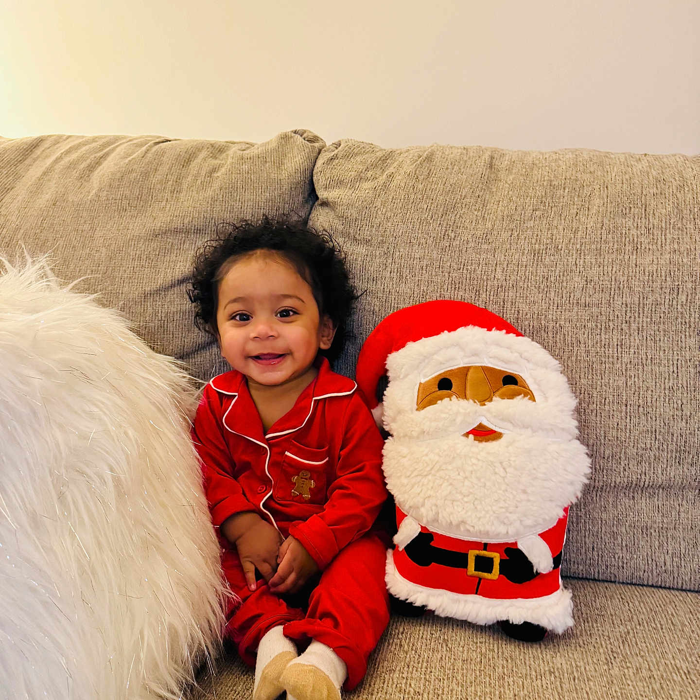 Reginald joined the competition — help win amazing prizes! child, couch, cozy, curly_hair, cute, festive, happy, holiday_theme, home, indoor, plush_toy, portrait, red_pajamas, santa_claus, seated, smiling, soft_texture, toddler, white_pillow, young_child