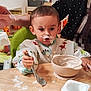 Soann a rejoint le concours — aidez-le/la à gagner de superbes lots ! baby, bib, child, clothing, expression, face, feeding, food, hand, highchair, indoor, kitchen, meal, messy, parent, smudge, spoon, table, toddler, yogurt