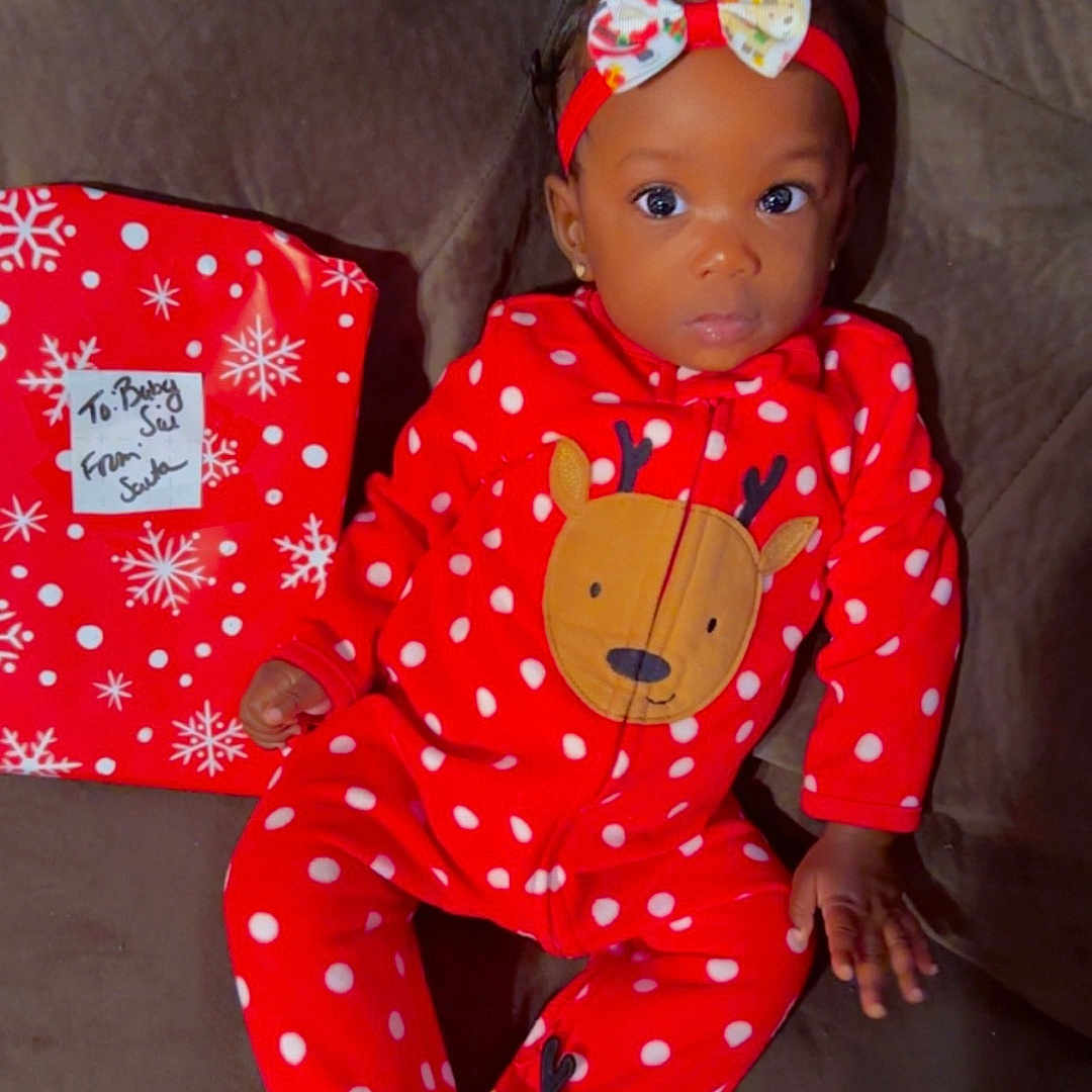 Kasai is registered to the contest to win money with this photo: applique, baby, clothing, couch, doll, dress, face, fashion, figurine, formalwear, furniture, gown, head, pajamas, pattern, person, toy