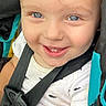 toddler, child, baby, smiling, happy, portrait, face, blue_eyes, teeth, close_up, car_seat, seatbelt, harness, sitting, white_shirt, patterned_clothing, indoor, vehicle, photography, adorable