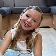 Brianna participe au concours pour gagner de l'argent avec cette photo : child, girl, smiling, long_hair, jeans, ripped_jeans, tank_top, sitting, floor, wooden_floor, indoor, living_room, couch, furniture, casual_clothing, happy, portrait, young, cute, relaxed