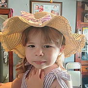 Rosey is registered to the contest to win money with this photo: baby_photos, bow, child, childhood, clothing, curious, expression, face, furniture, hair, hand, hat, indoor, person, photo_frame, portrait, room, straw_hat, thoughtful, toddler