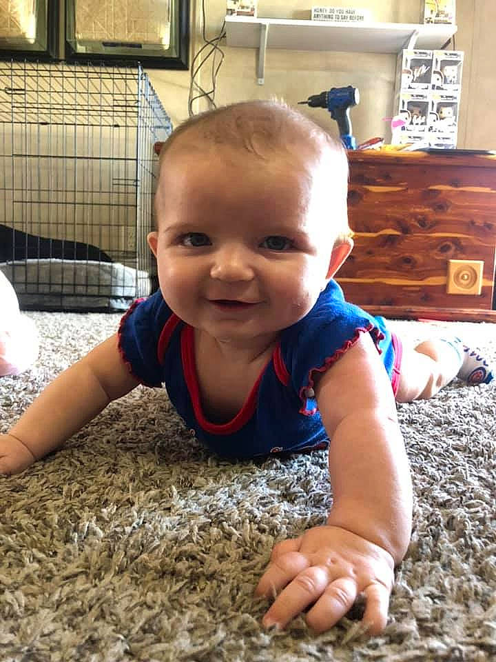 Addison is registered to the contest to win money with this photo: baby, cheek, child, crawling, electronic_device, face, facial_expression, floor, flooring, fun, head, joy, person, play, skin, smile, technology, toddler, tummy_time, vacation