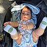 Nikko Lee is registered to the contest to win money with this photo: baby, infant, stroller, blanket, socks, legs, hands, clothing, face, expression, child, cute, outdoor, sunlight, fabric, pattern, animal_print, playful, reaching, soft