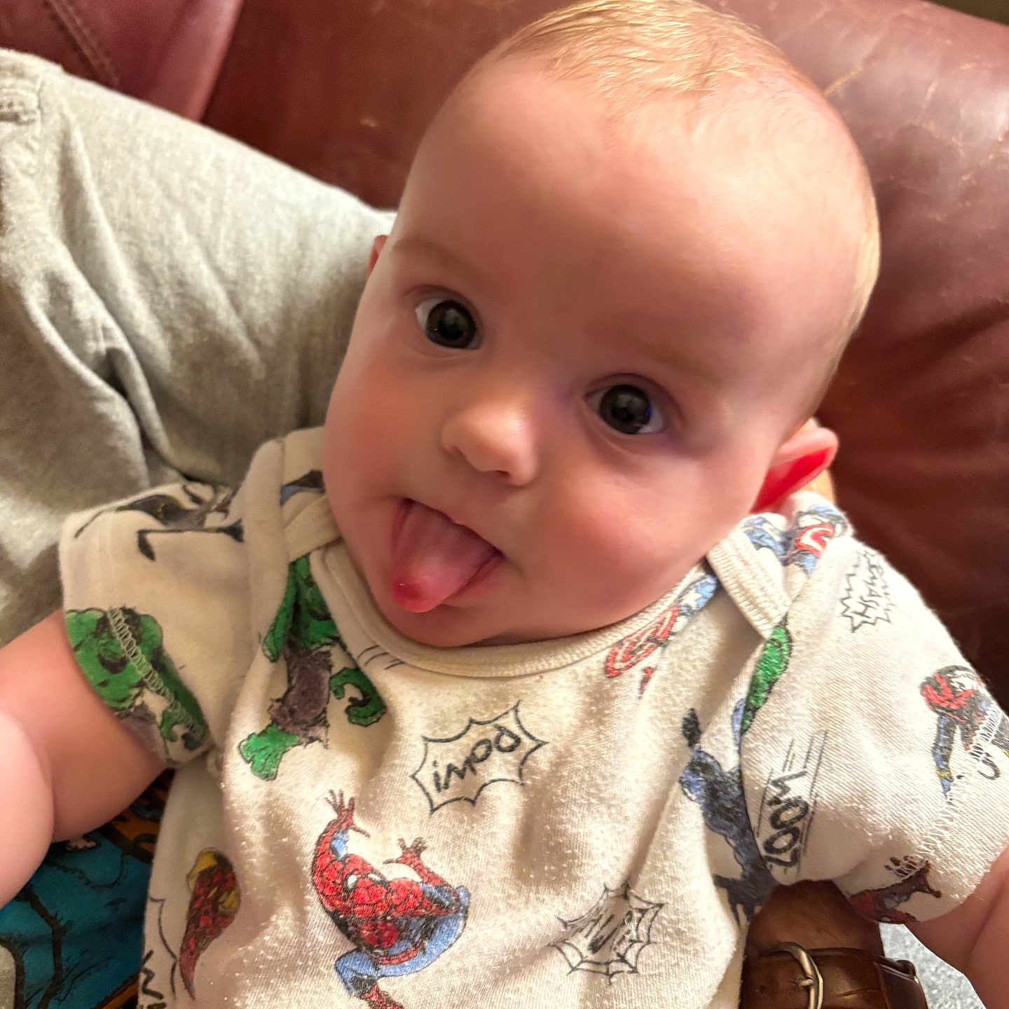 Khaison joined the competition — help win amazing prizes! adult, baby, captain_america, child, clothing, couch, cute, face, hand, head, indoor, infant, leather, onesie, person, playful, smile, spiderman, superhero, tongue_out