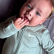 Joris a rejoint le concours — aidez-le/la à gagner de superbes lots ! baby, child, face, blue_eyes, blonde_hair, hand, clothing, nike_logo, zip_up, portrait, cute, infant, playful, expression, lying_down, indoor, skin, young_child, person, closeup