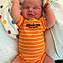arm, baby, blanket, child, clothing, cute, face, hand, indoors, infant, lying_down, newborn, onesie, orange, peaceful, polka_dot, resting, sleeping, soft, striped