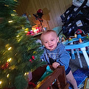 Brentlee joined the competition — help win amazing prizes! toddler, child, christmas_tree, holiday_lights, toy, indoor, baby_gear, hoodie, mickey_mouse, carpet, wood_paneling, furniture, play_area, smiling, barefoot, decorations, candle, cozy, family_photo, home