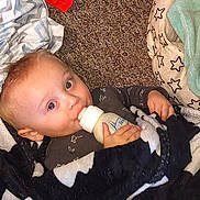 Brentlee is registered to the contest to win money with this photo: baby, bottle, blanket, carpet, child, clothing, face, hand, indoor, infant, milk, person, portrait, resting, sleepwear, soft, toddler, young_child, cute, feeding