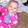 Eleeah is registered to the contest to win money with this photo: baby, bottle, carpet, child, clothing, drink, face, hand, infant, lying_down, pajamas, person, pink, blanket, floor, young_child, indoors, feeding, cute, cozy